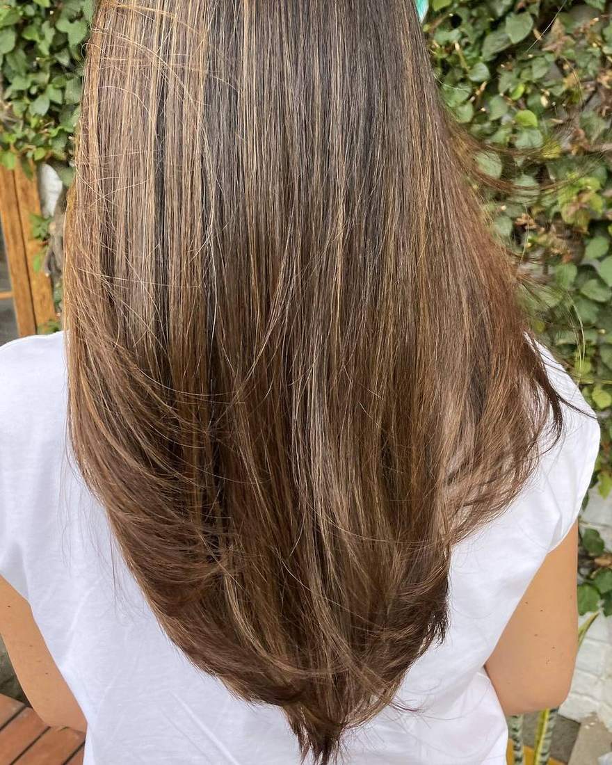 Corte largo en capas sobre castaño, con el movimiento de las puntas visible, Quito