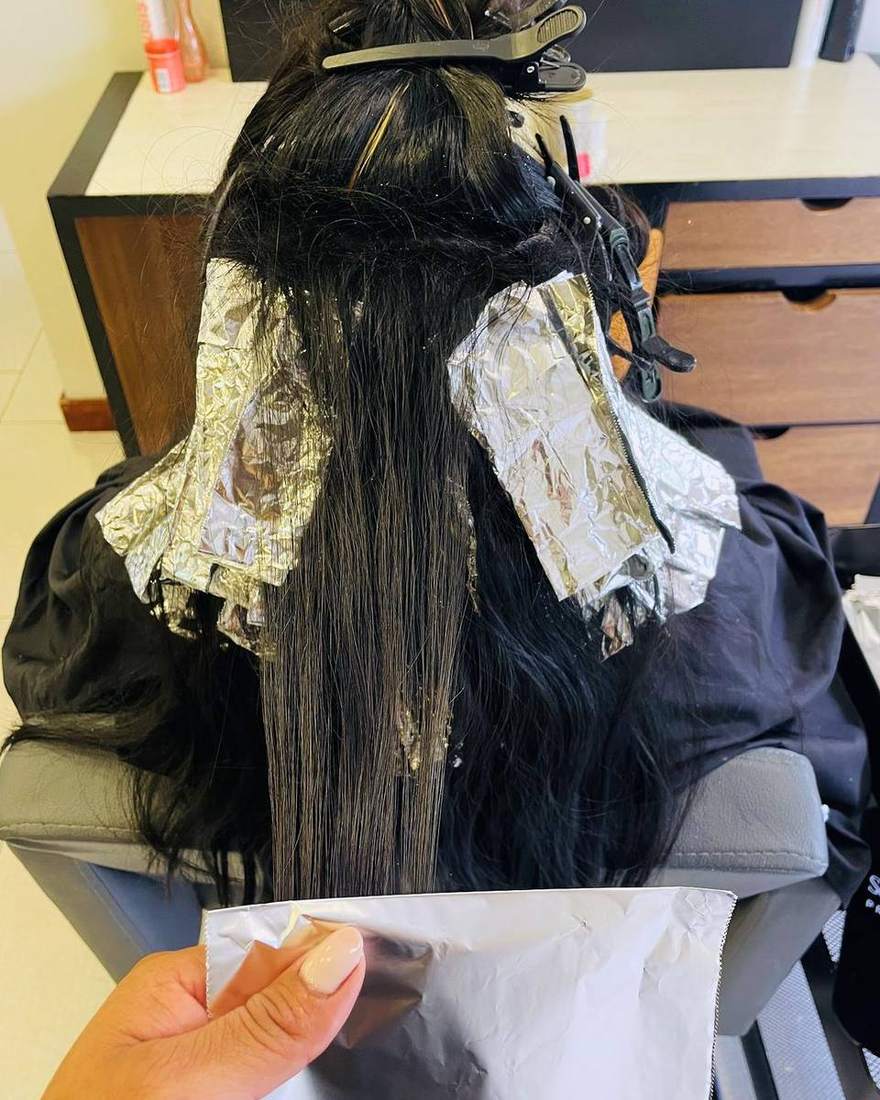 Mechas en proceso con papel aluminio sobre cabello oscuro, Quito