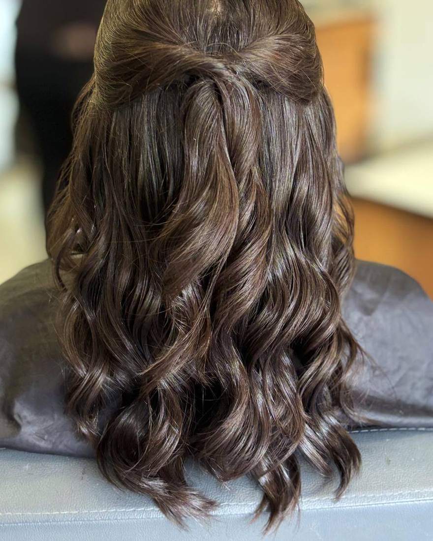 Semirecogido con ondas definidas sobre cabello oscuro, peinado para evento en Quito